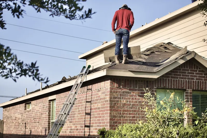 Professional roofer working on a residential roof in East Saxton